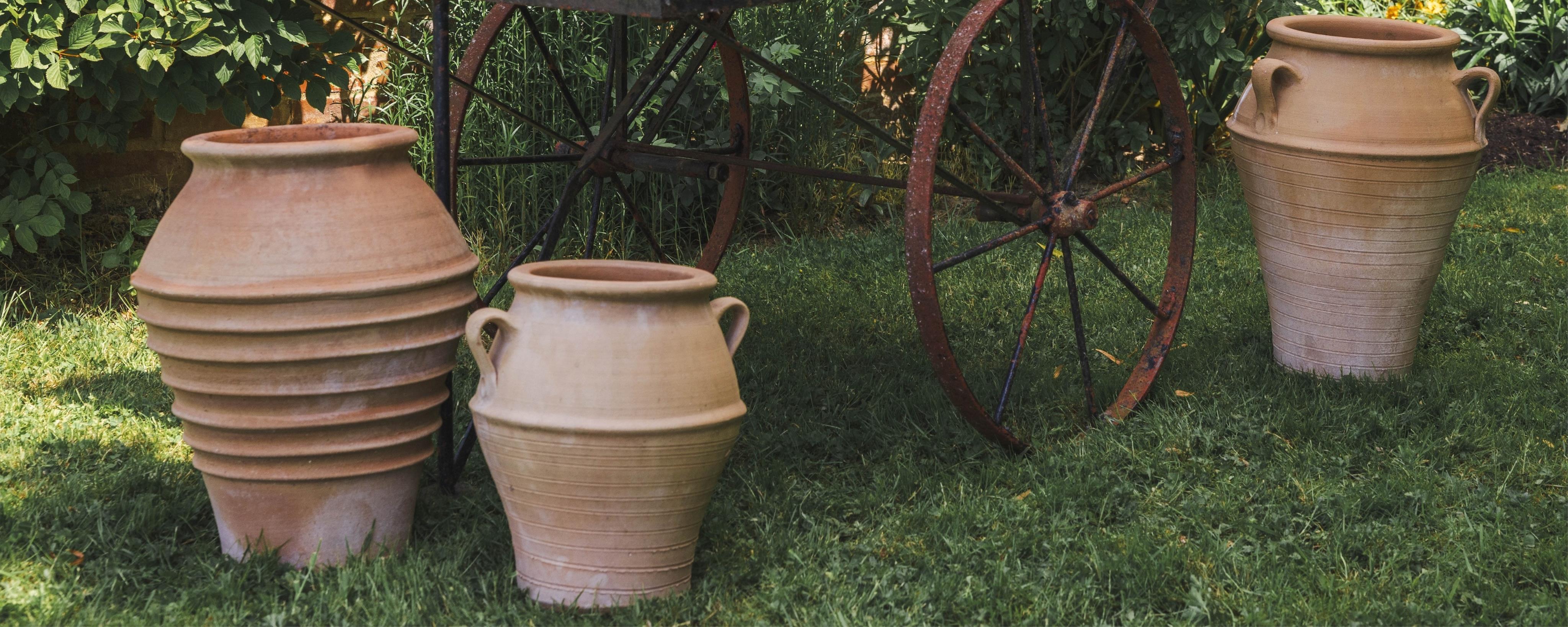 Three Grecian style circular terracotta garden planters, height 55cm